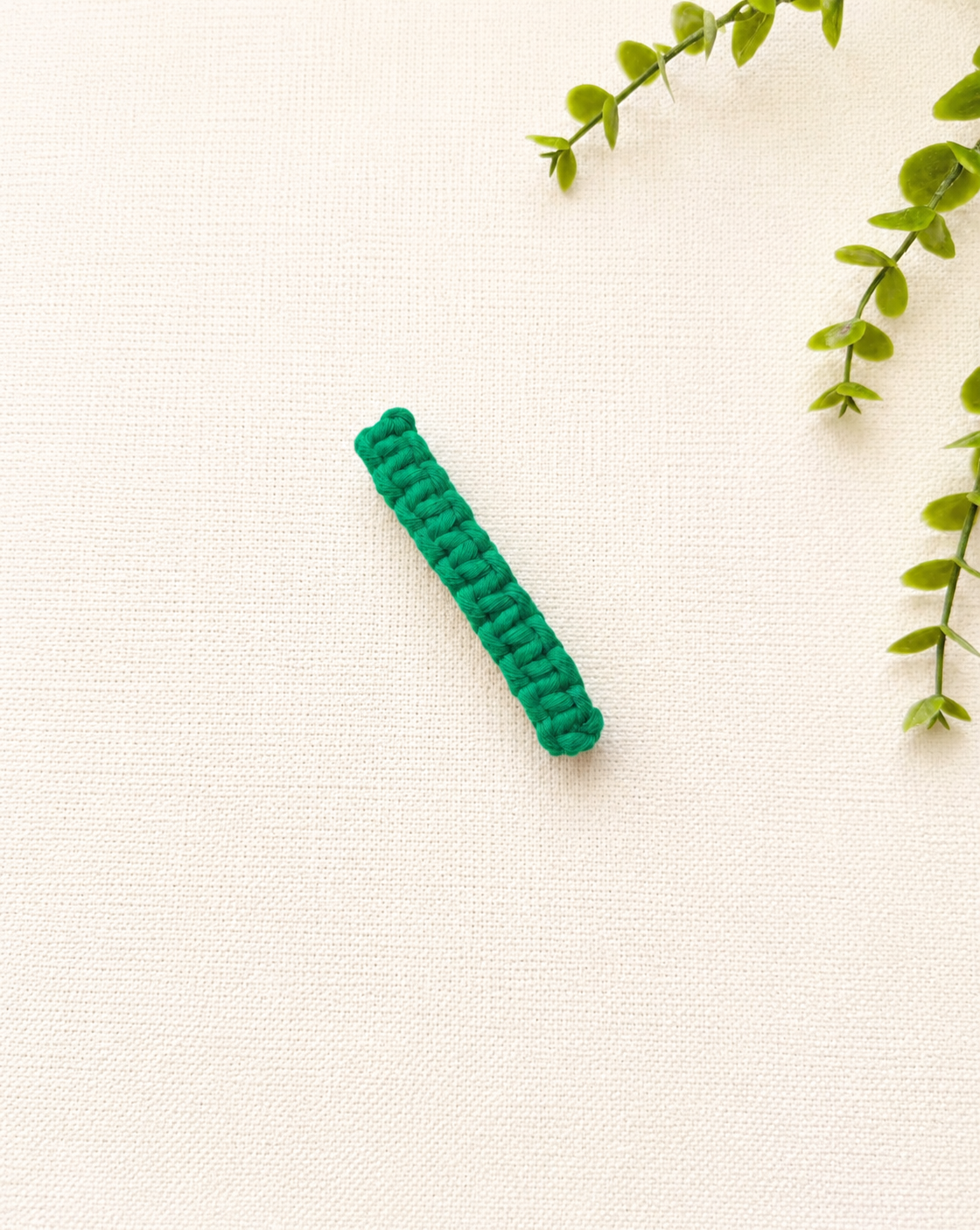 Green handmade macramé hair clip with woven macramé pattern