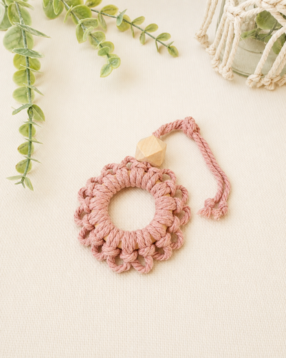 Handmade blush pink macrame flower car diffuser with a natural wooden bead for essential oils and car décor.