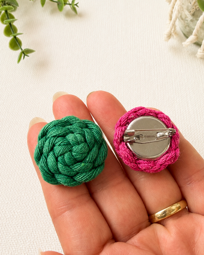 Handmade macrame button brooch shown in hand for size reference