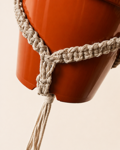 Close up of cotton macrame plant holder supporting a hanging plant pot