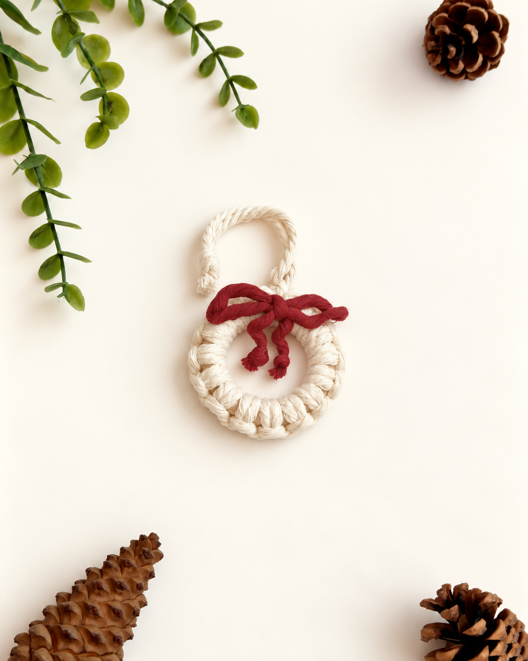 Cream macrame Christmas wreath ornament with burgundy bow