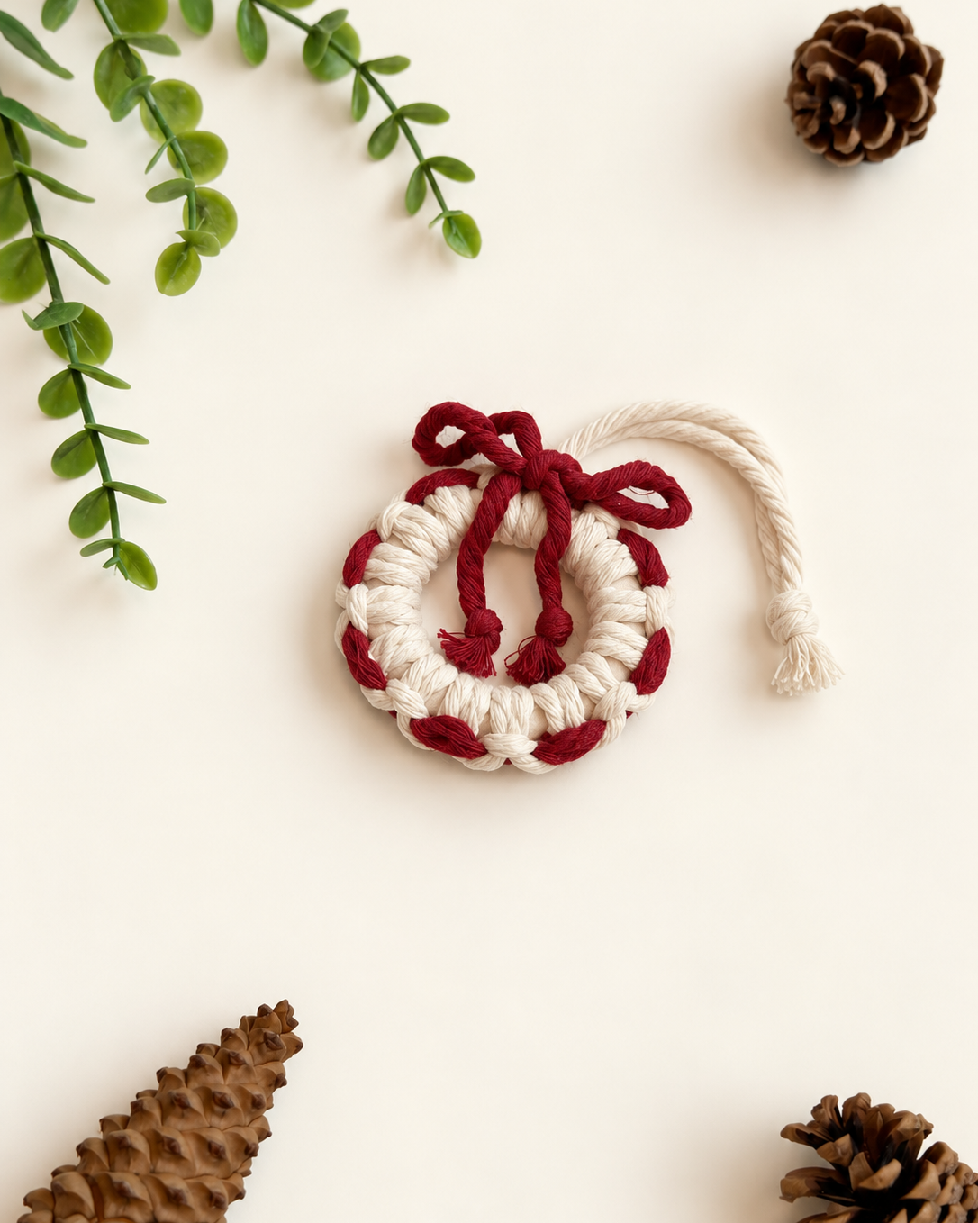 Cream macrame wreath Christmas ornament with burgundy woven detail and bow