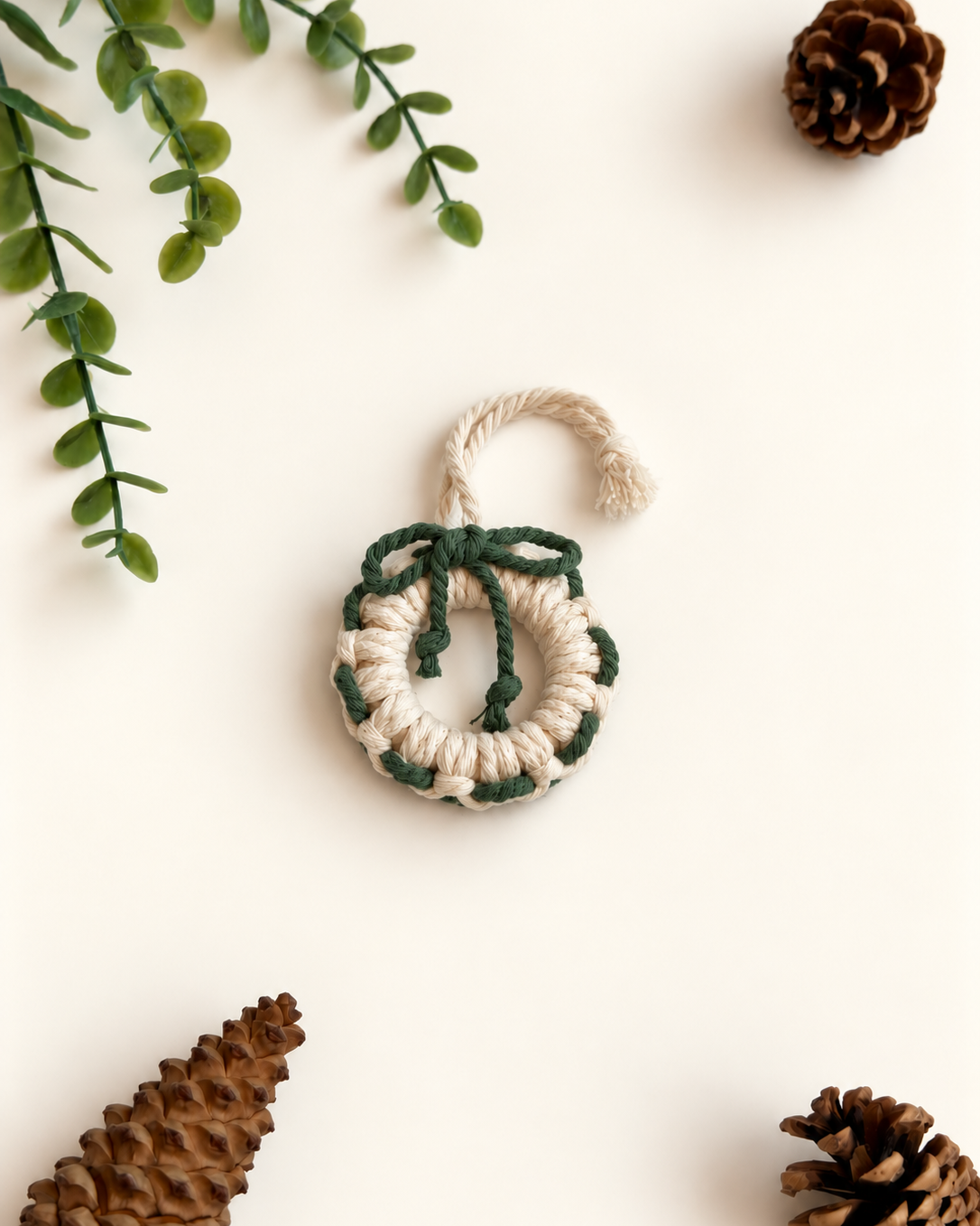 Cream macrame Christmas wreath ornament with green bow and woven detail