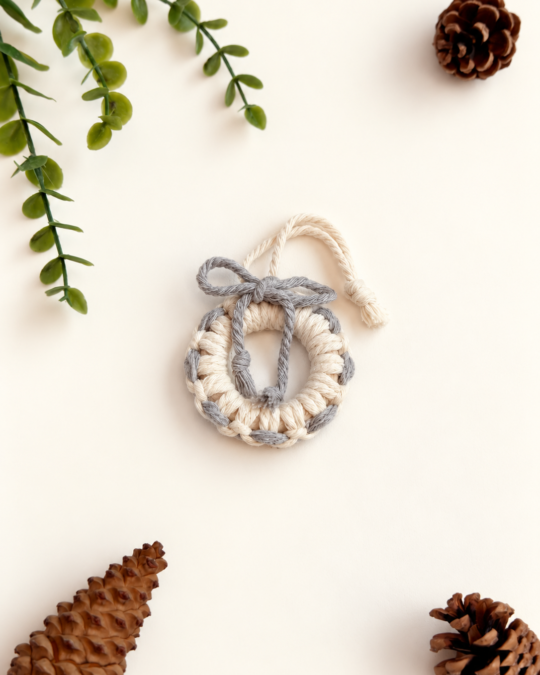 Cream macrame Christmas wreath ornament with grey bow and woven detail