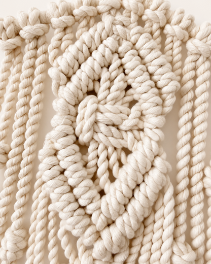 Close-up of handmade diamond knot detail on macrame star wall hanging