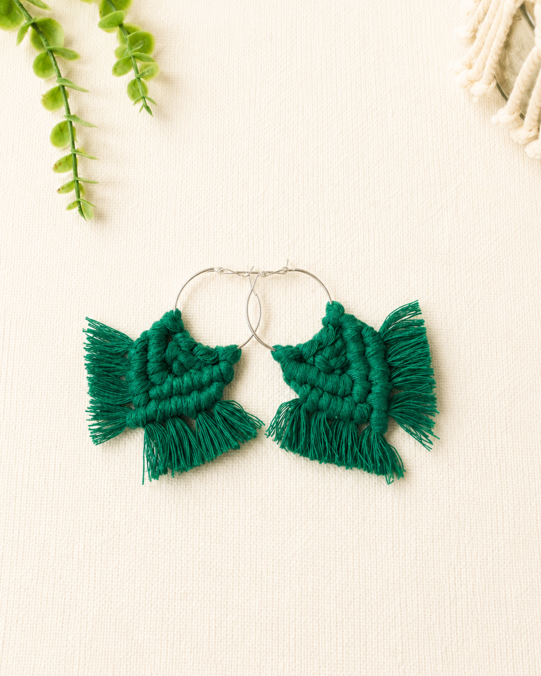 Handmade emerald green macrame chevron hoop earrings with silver hoops and cotton fringe.