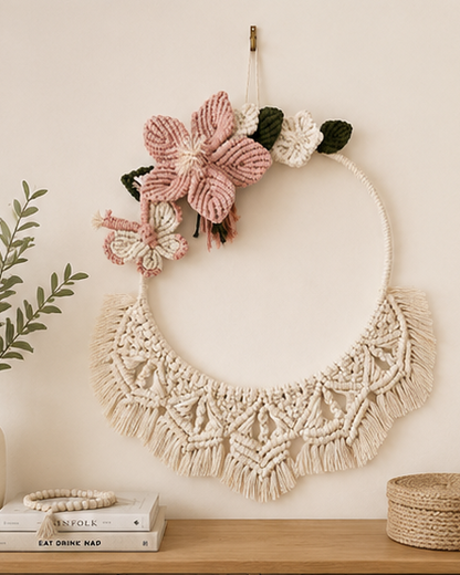 Handmade floral macrame wall hanging with pink flowers and butterfly styled in a boho interior
