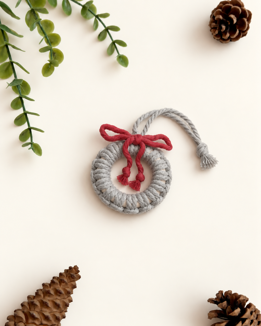 Grey macrame Christmas wreath ornament with burgundy bow