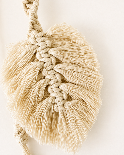 Close-up of handmade off-white cotton macrame leaf and knot detail