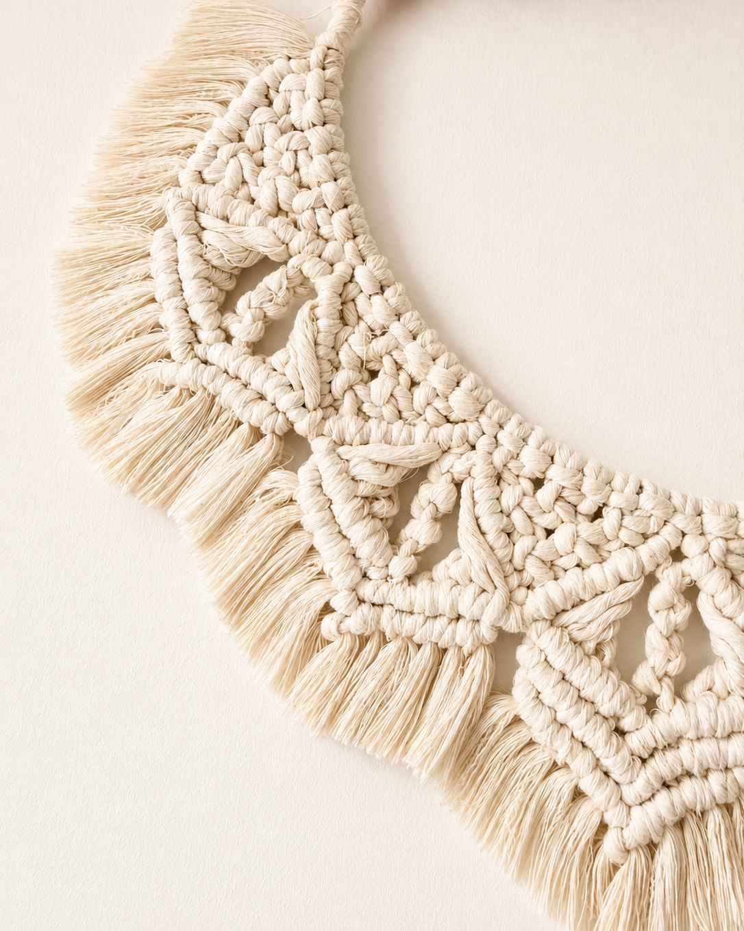 Detailed handmade macrame wall art with decorative knots and natural cotton fringe