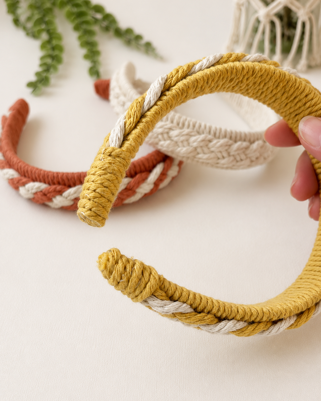 Side view of a handmade macrame headband showing the braided detail