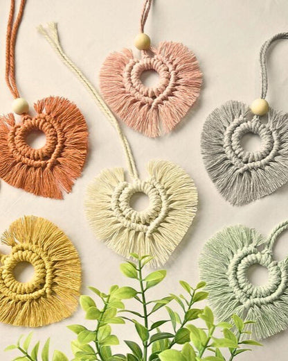 Handmade heart-shaped macramé car diffusers in soft boho colors with wooden beads, styled on a neutral background – Samra Knots.
