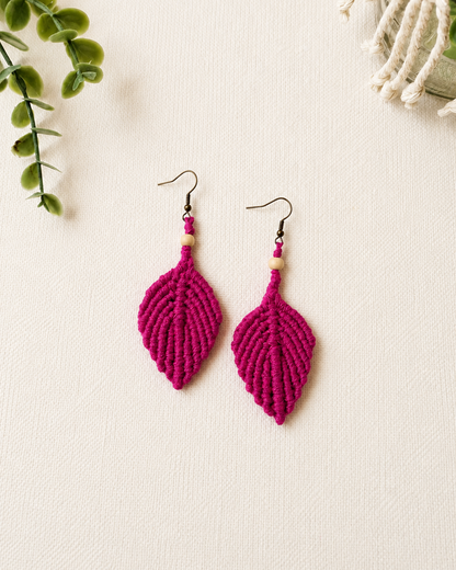 Handmade hot pink macrame leaf earrings with wooden bead detail and antique bronze hooks.