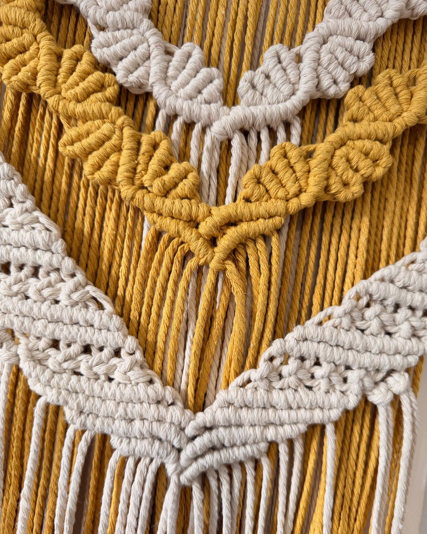 Detailed view of the layered macrame wall hanging highlighting the handcrafted cotton knot patterns and textured design.