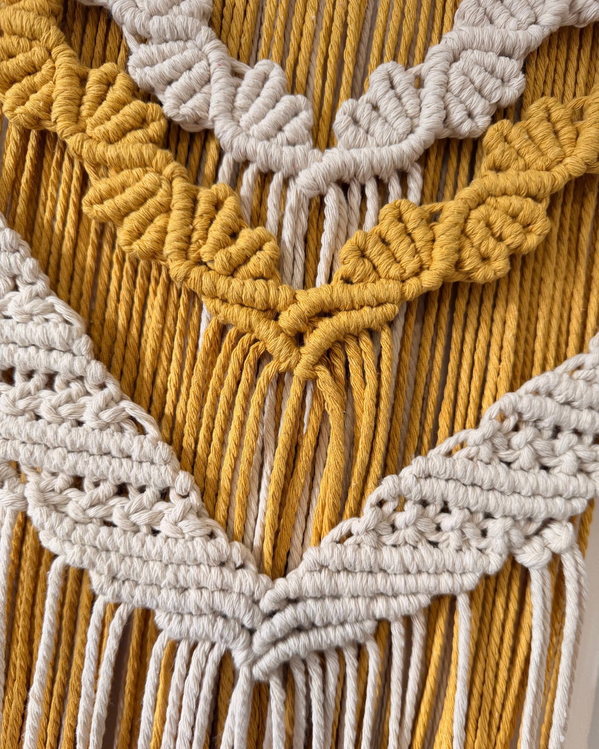 Detailed view of the layered macrame wall hanging highlighting the handcrafted cotton knot patterns and textured design.