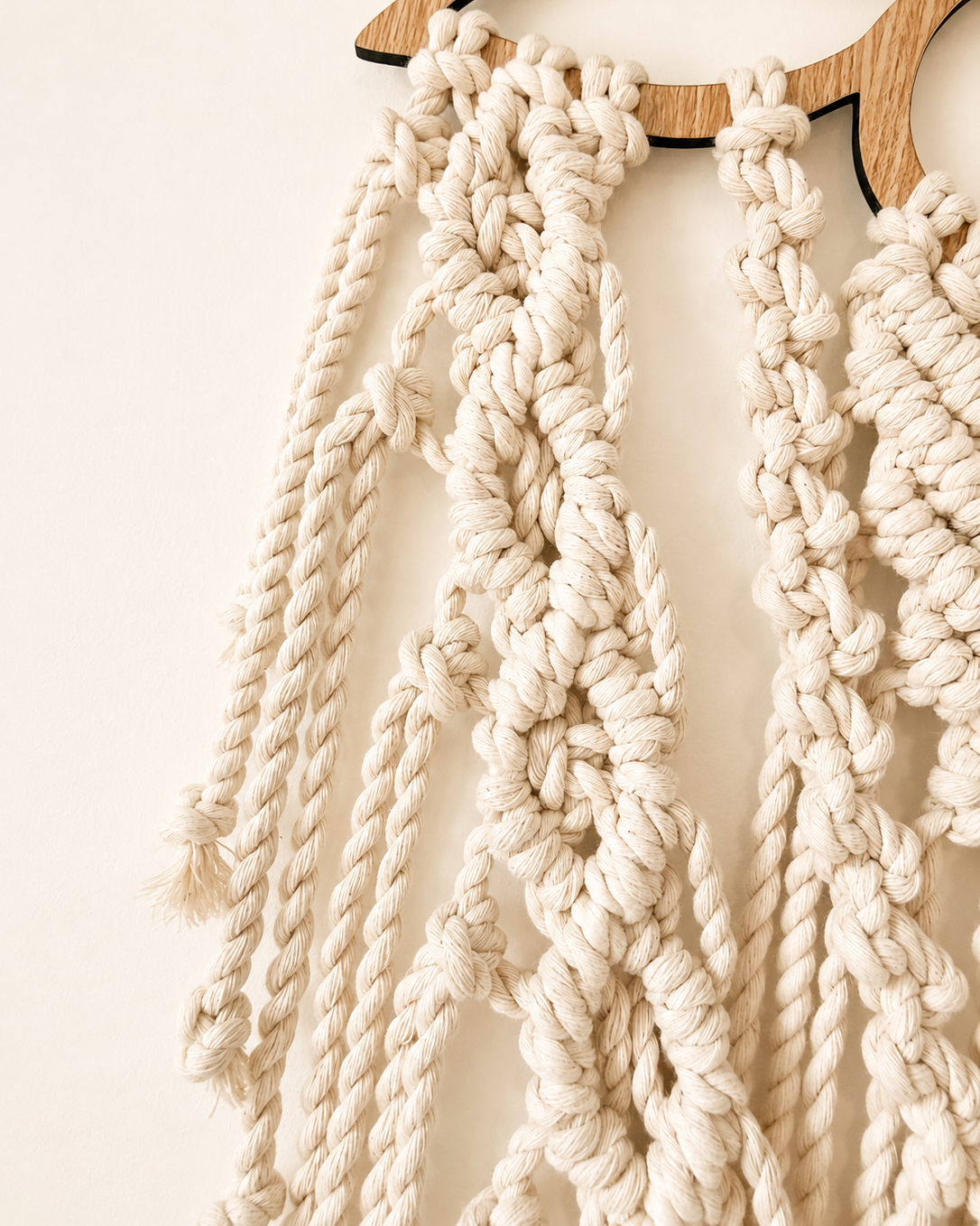 Close-up of braided side cords and decorative knots on the lotus macrame wall hanging.