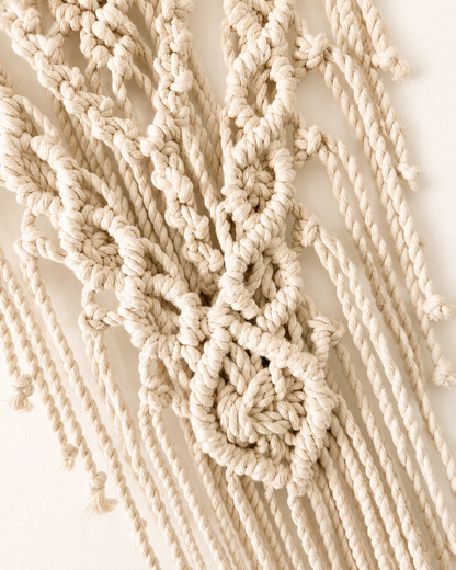 Close-up of the decorative diamond knot and fringe on the lotus macrame wall hanging.