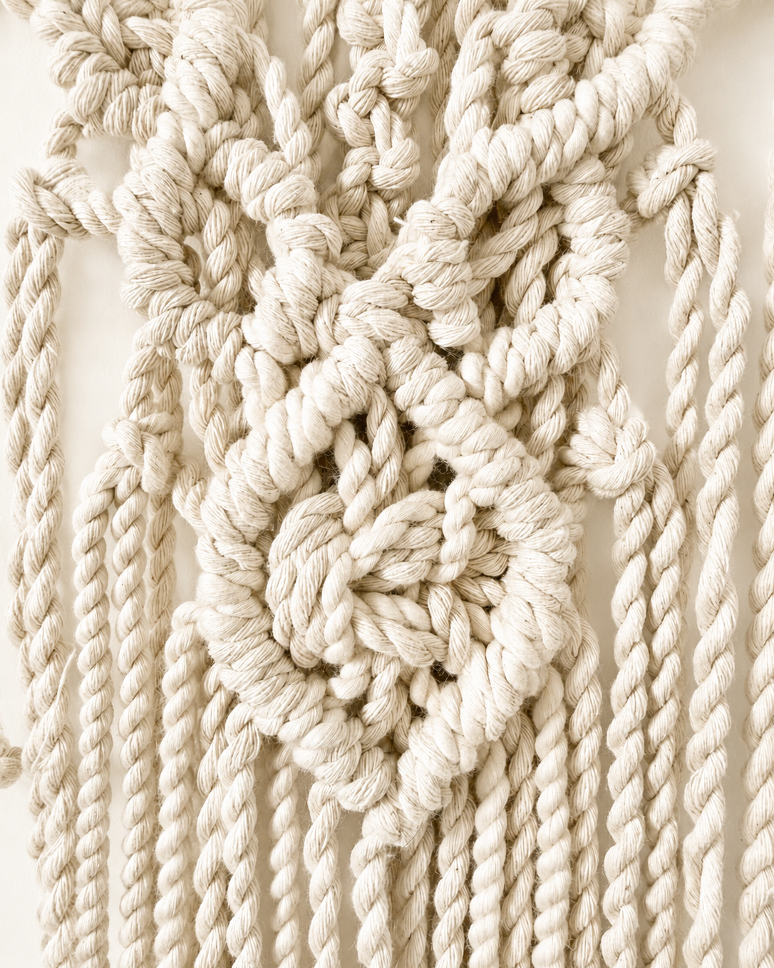 Close-up of the side knot pattern on the handmade lotus macrame wall hanging.