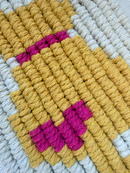 Close-up detail of a handmade macrame cat wall hanging showing woven cotton knots and mustard yellow cat design.