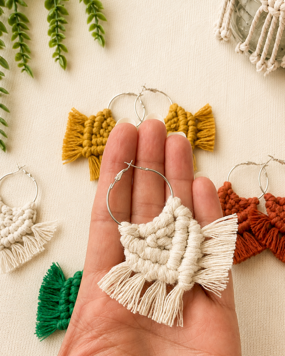 Handmade off white macrame chevron hoop earring shown in hand for size reference.