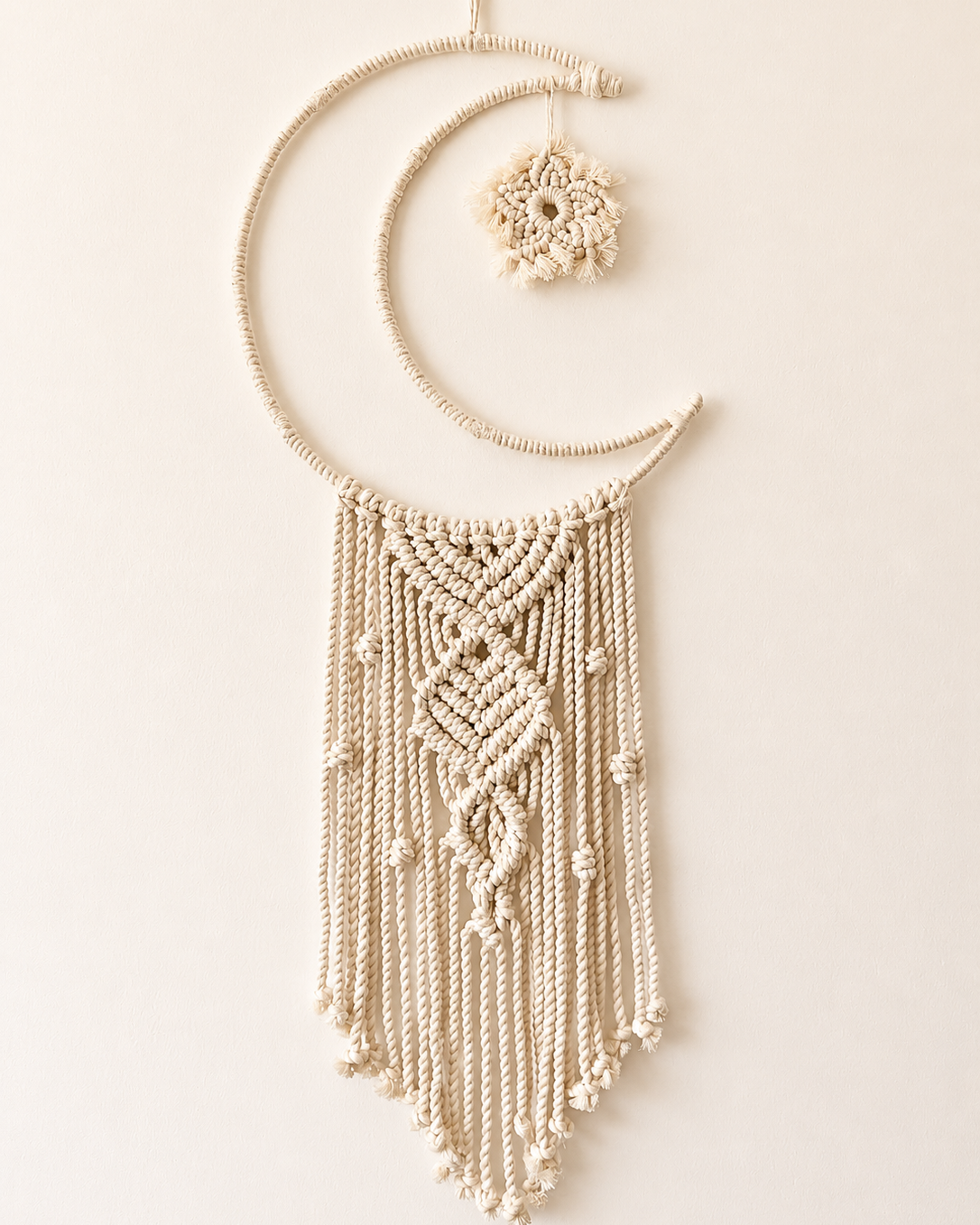 Handmade macrame crescent moon wall hanging with textured central knot design