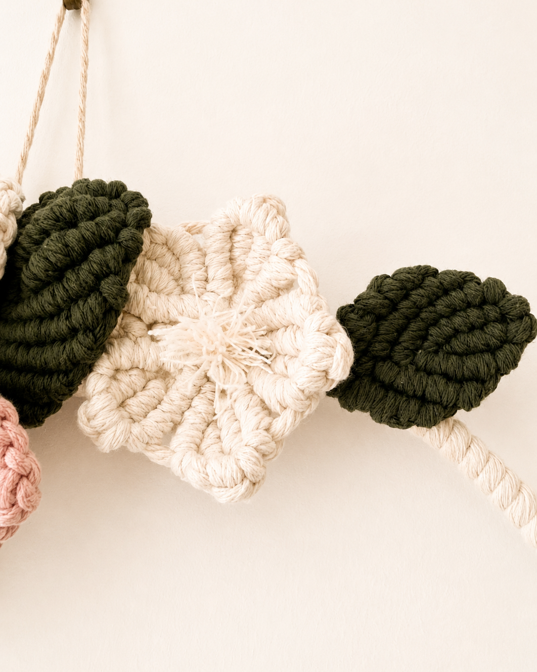 Handmade natural cotton macrame flower with dark green leaves