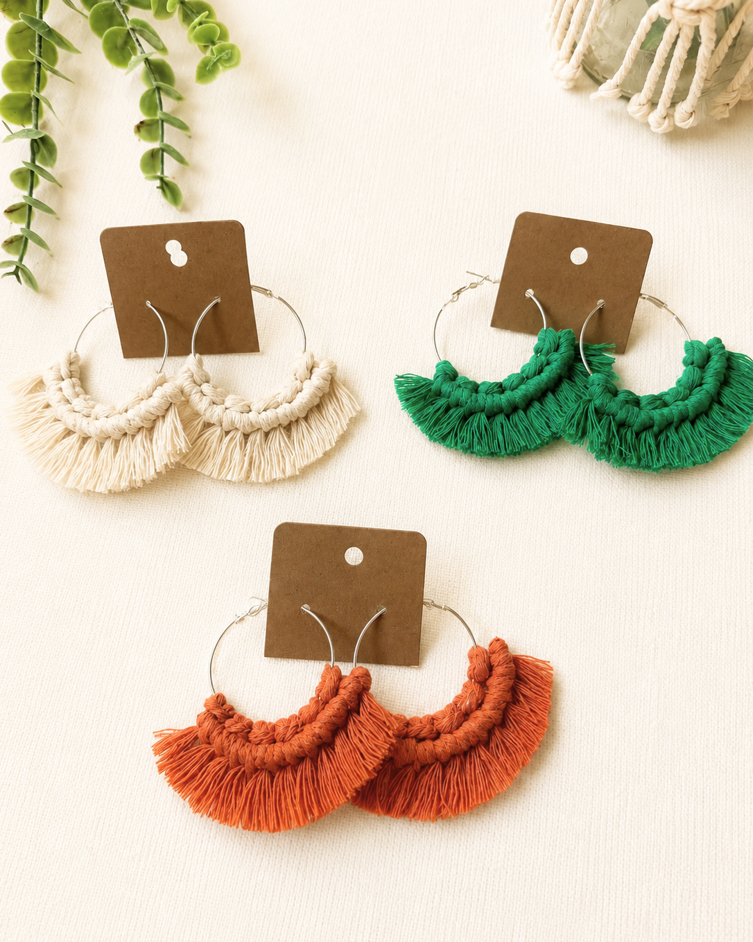 Handmade macrame fringe hoop earrings displayed on kraft jewellery cards in multiple colours.