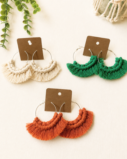 Handmade macrame fringe hoop earrings displayed on kraft jewellery cards in multiple colours.