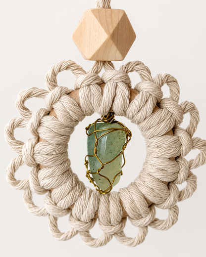 Close-up of a handmade macrame gemstone car charm featuring a natural green gemstone and unfinished wooden diffuser bead.