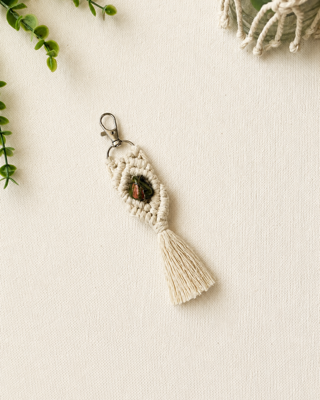 Handmade green and orange macrame gemstone keychain with a natural gemstone, cotton tassel and silver clasp.
