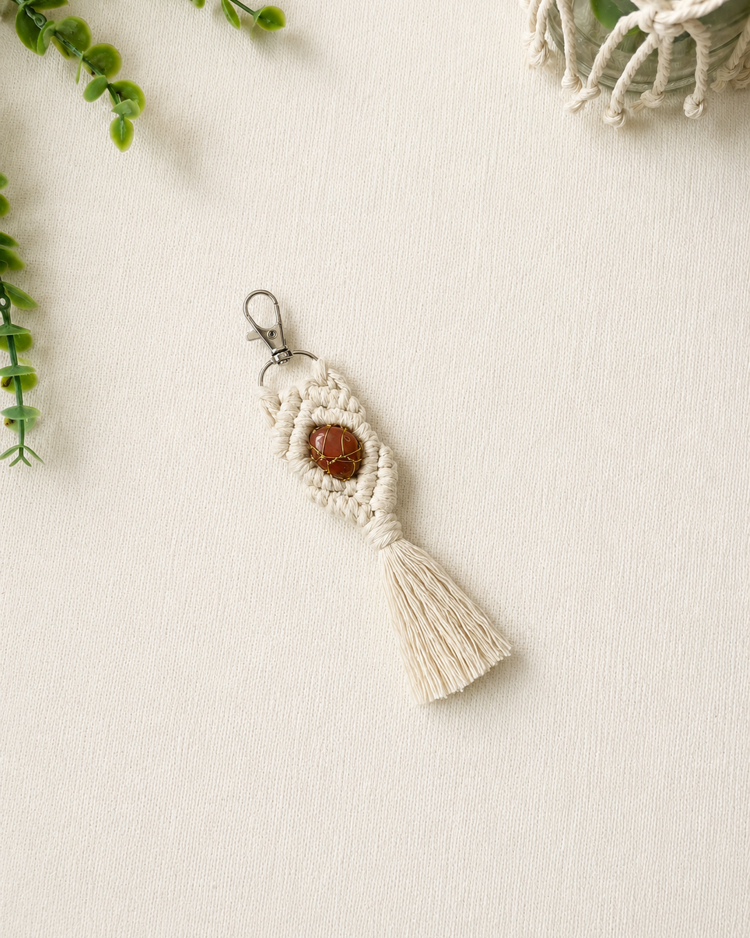 Handmade orange macrame gemstone keychain with a natural gemstone, cotton tassel and silver clasp.