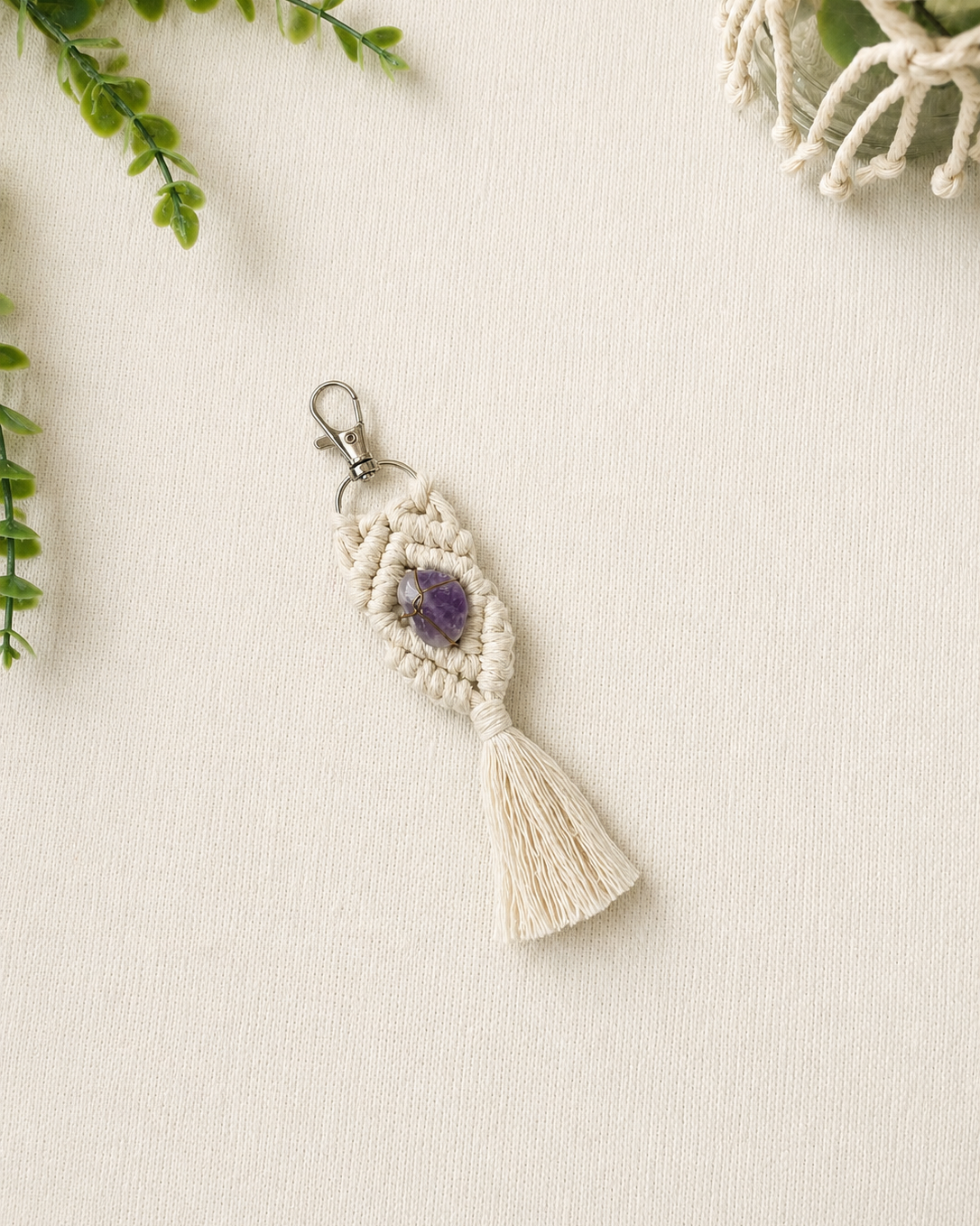 Handmade purple macrame gemstone keychain with a natural gemstone, cotton tassel and silver clasp.