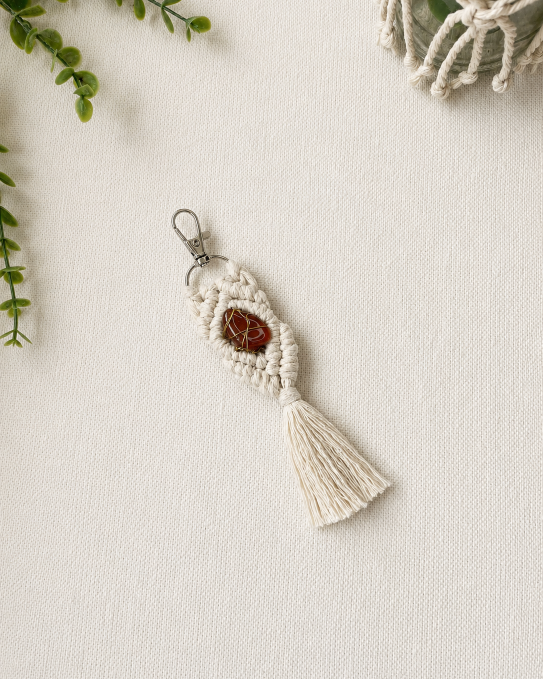 Handmade red macrame gemstone keychain with a natural gemstone, cotton tassel and silver clasp.