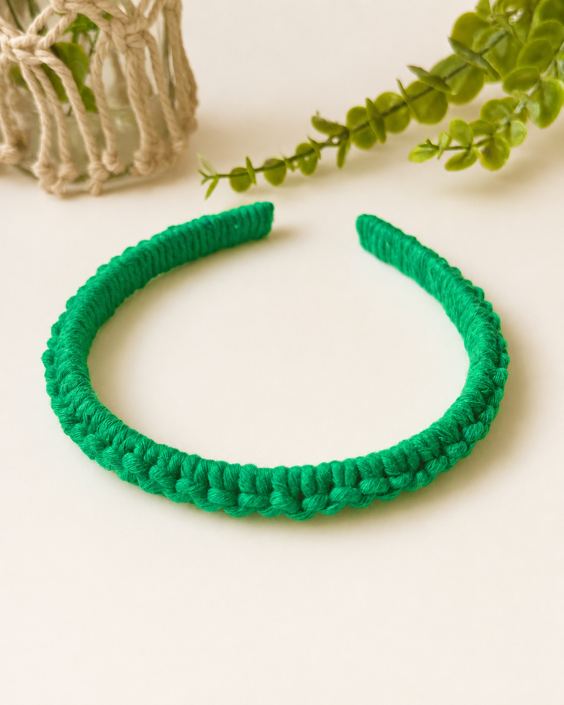 Green handmade macramé headband crafted with cotton cord.