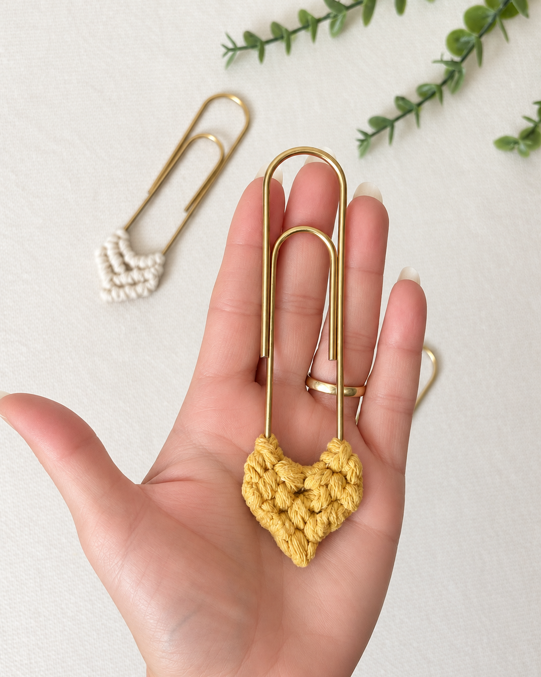 Back view of handmade mustard macramé heart bookmark with gold paper clip