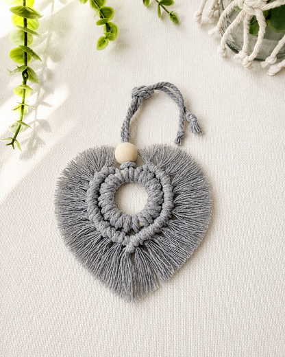 Grey macrame heart car charm with fringe and wooden bead, handmade boho rear view mirror charm.
