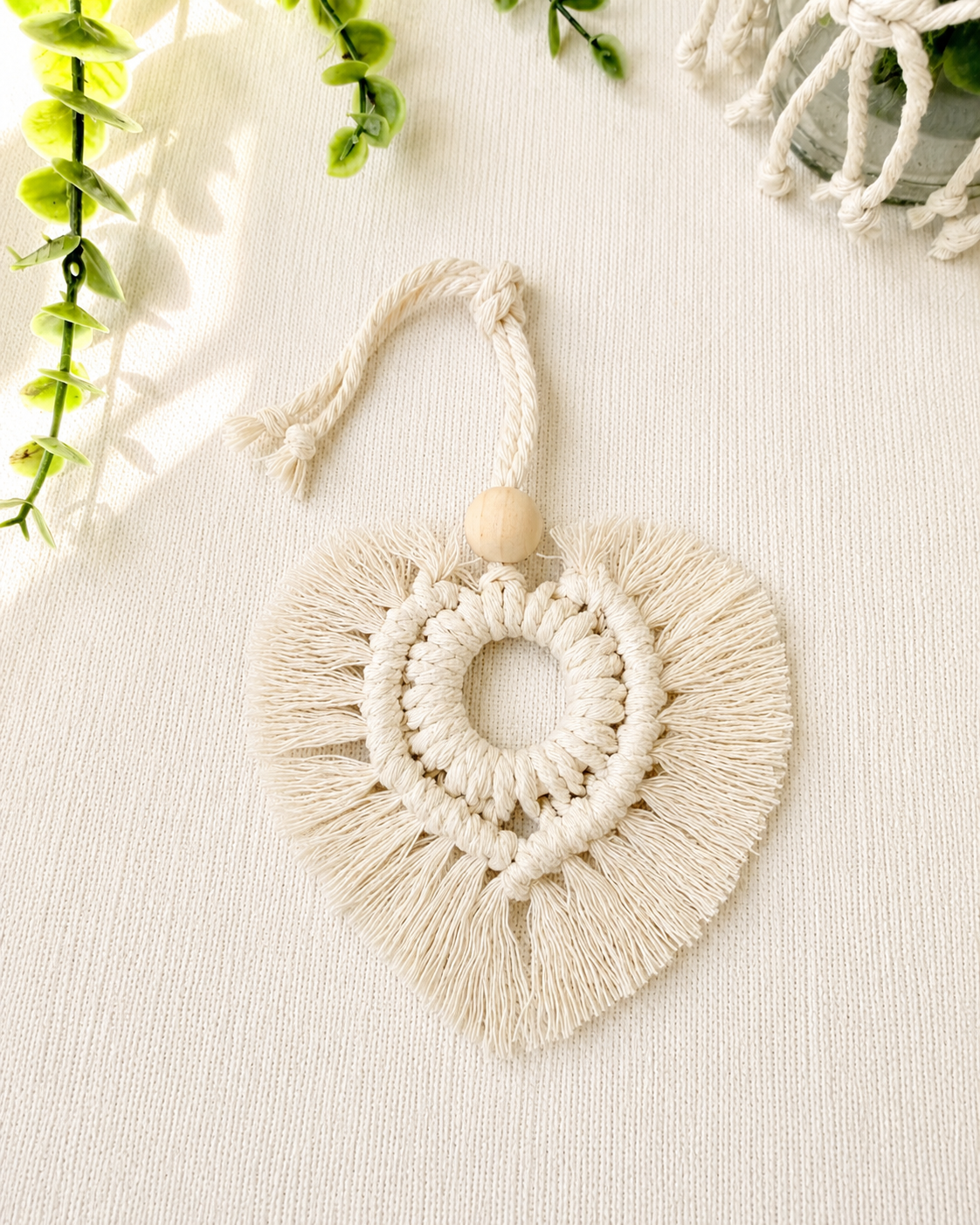 Natural macrame heart car charm with fringe and wooden bead, handmade boho rear view mirror charm.