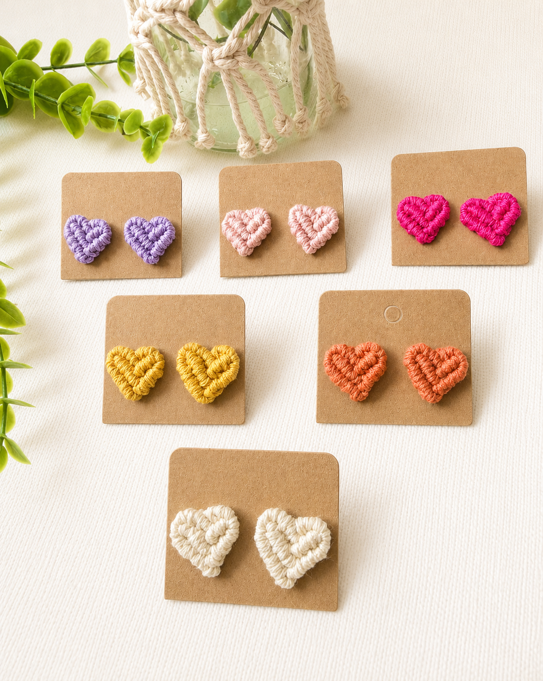 Macramé heart stud earrings available in six colours displayed on kraft jewellery cards.