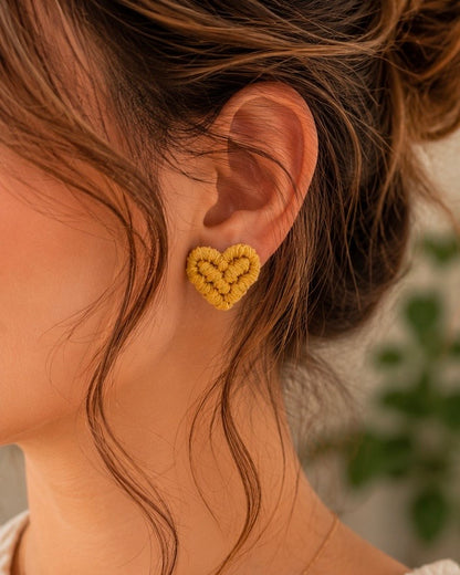 Woman wearing handmade mustard macramé heart stud earrings