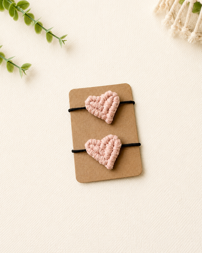 Handmade blush pink macrame heart hair ties on black elastic ponytail holders.