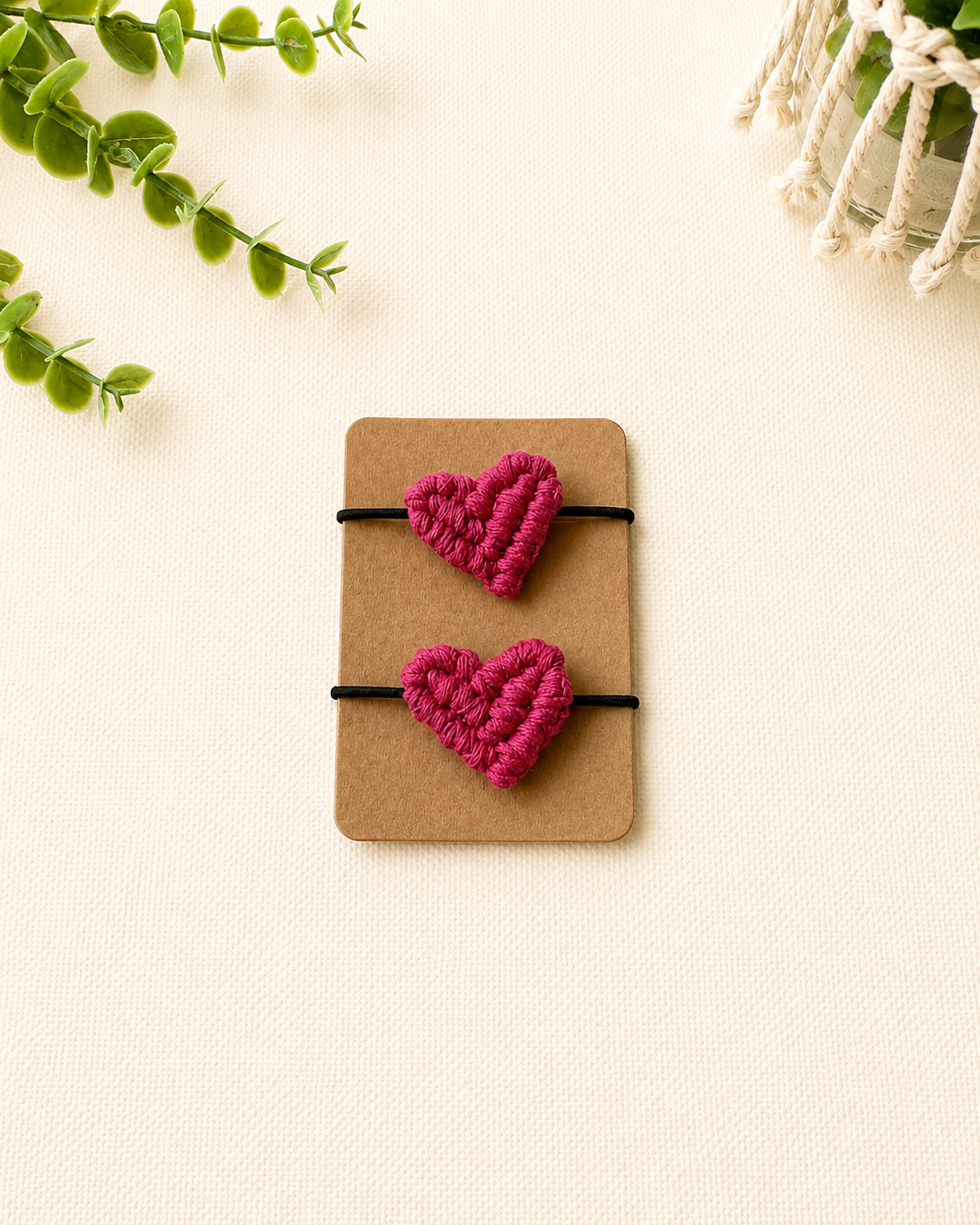 Handmade hot pink macrame heart hair ties on black elastic ponytail holders.