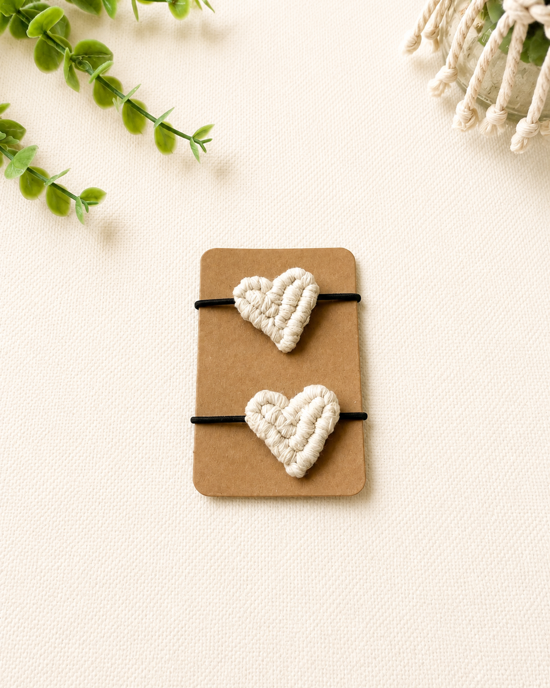 Handmade off white macrame heart hair ties on black elastic ponytail holders.