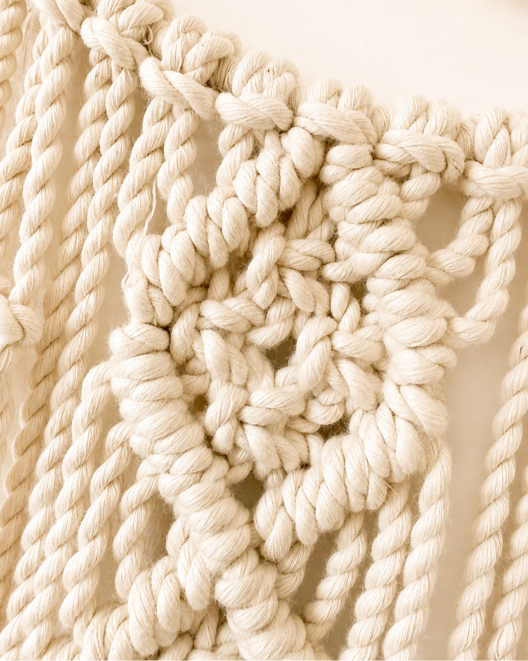 Detailed view of Egyptian cotton macrame knots on crescent moon wall decor