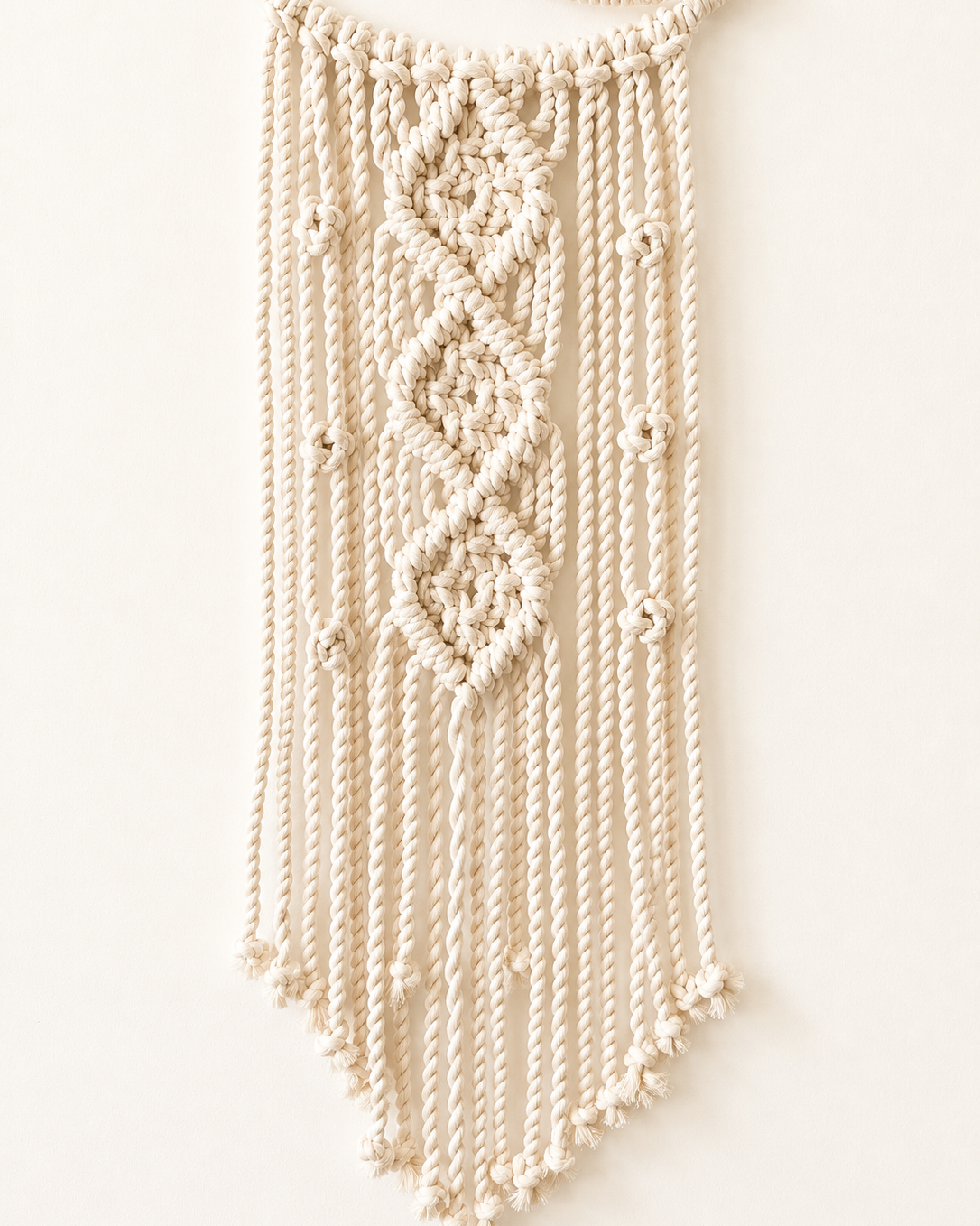 Close-up of geometric knots and Egyptian cotton cords on macrame moon wall hanging