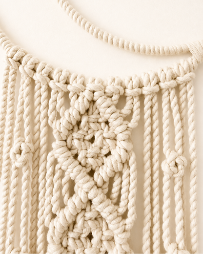 Close-up of handmade knotted detail on crescent moon macrame wall hanging