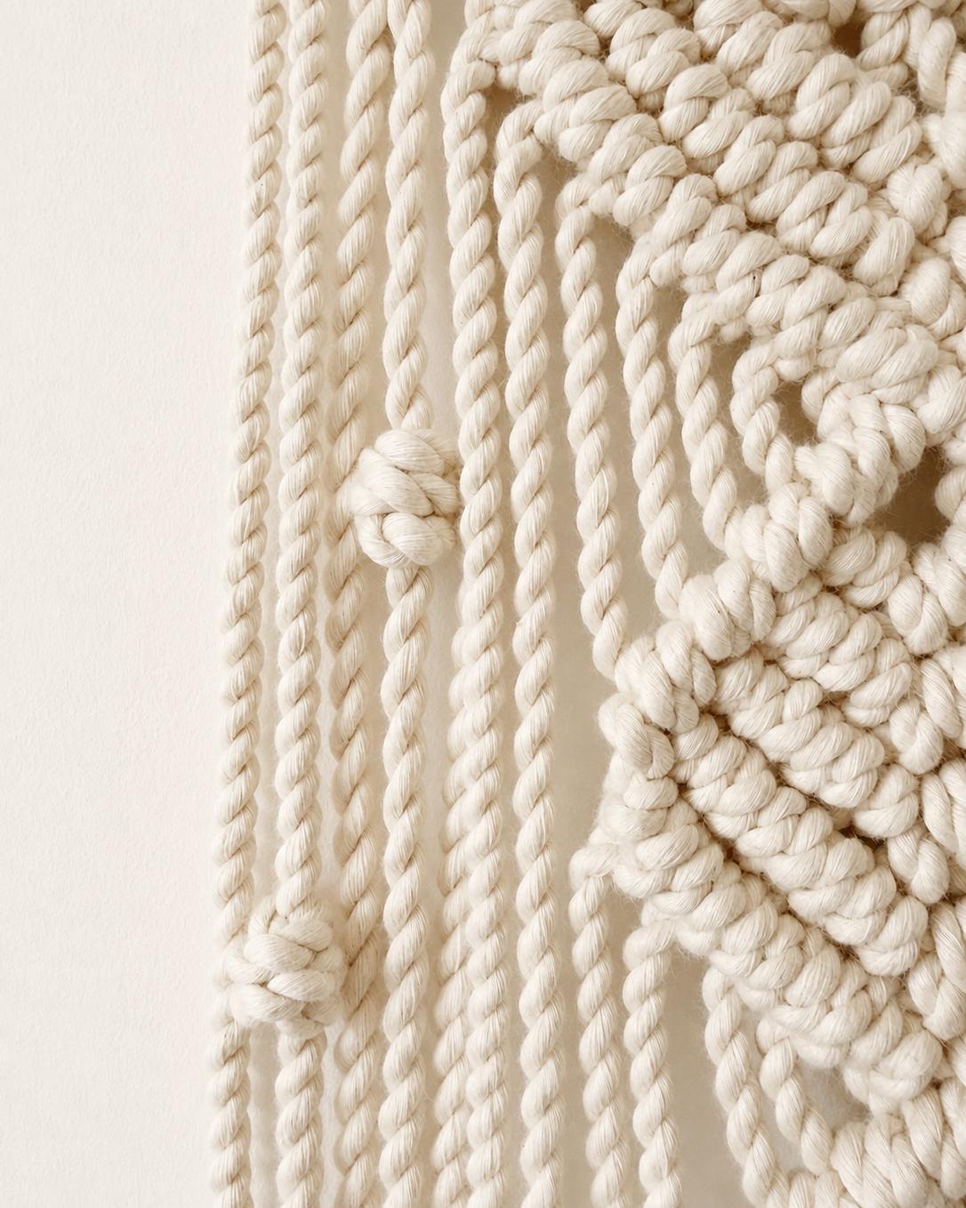Detailed side view of handmade knots and cords on macrame moon wall hanging