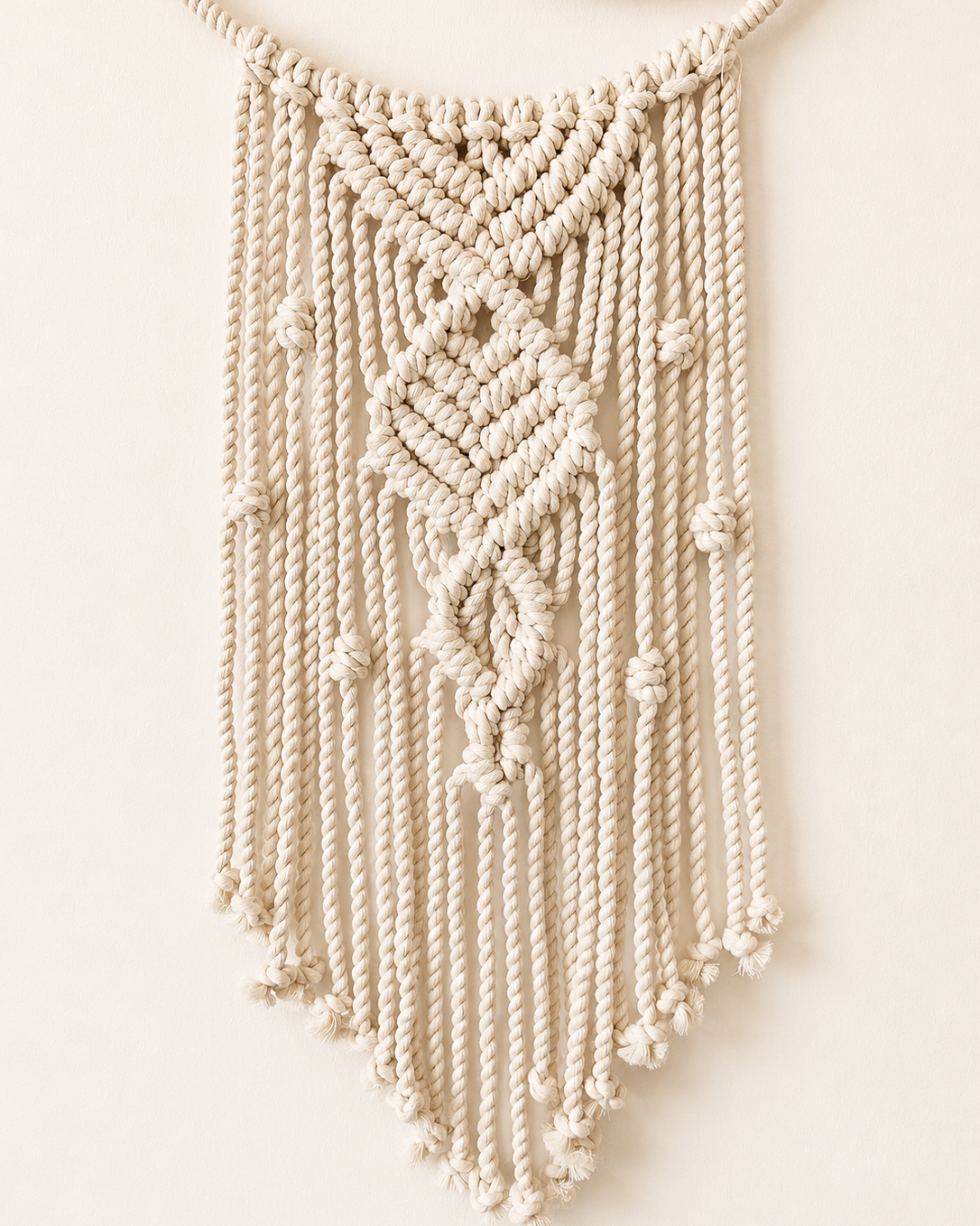 Handmade macrame crescent moon wall hanging with textured central knot design