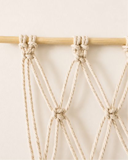 Close-up of macrame photo display attached to a natural wooden dowel