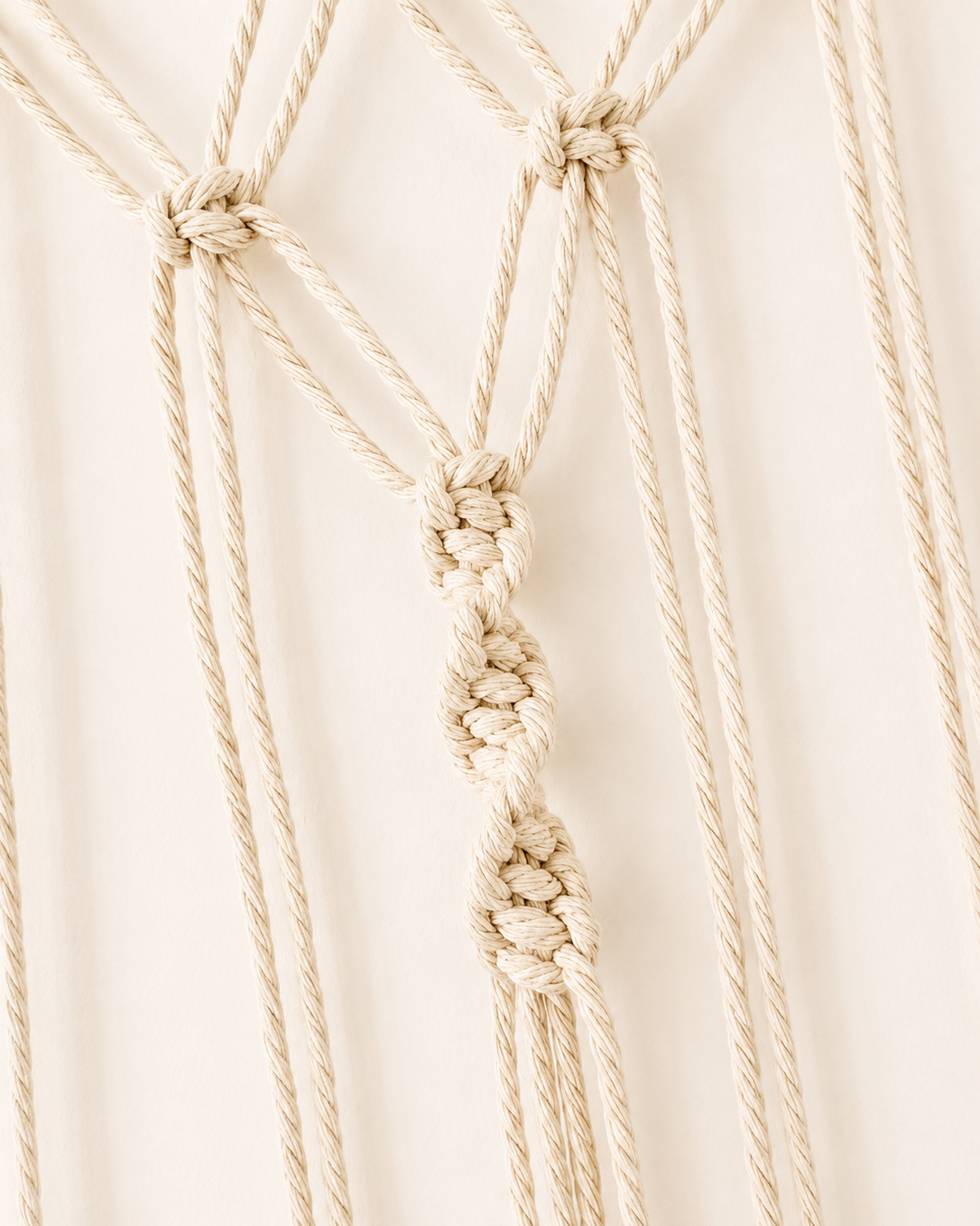 Close-up of decorative centre knots on handmade macrame photo holder