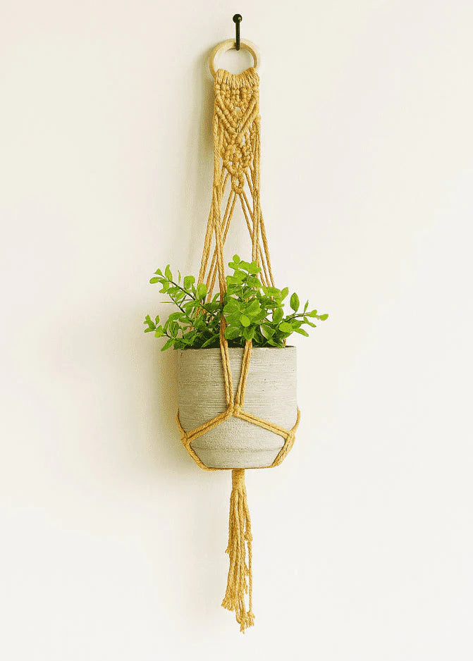 Mustard yellow handmade macramé plant hanger with a grey pot and green plant, adding cozy boho style to home decor – Samra Knots.